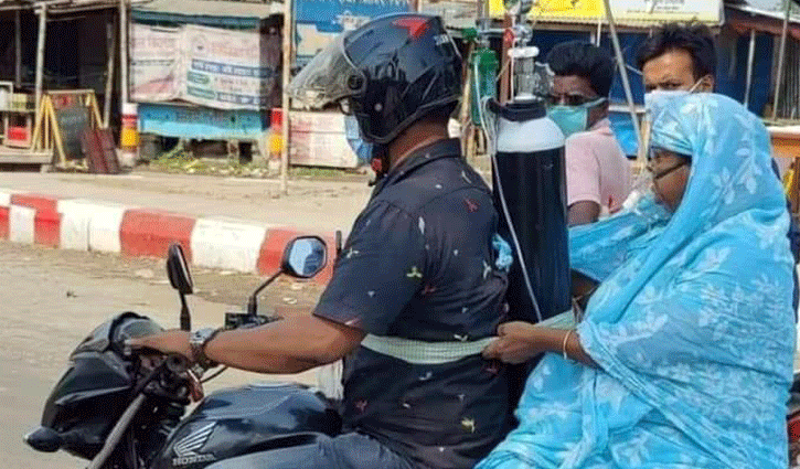 পিঠে অক্সিজেন সিলিন্ডার বেঁধে মাকে নিয়ে হাসপাতালে পিঠে অক্সিজেন সিলিন্ডার বেঁধে মাকে নিয়ে হাসপাতালে