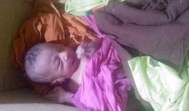 কাগজের বাক্সে মুখে স্কচটেপ আটকানো নবজাতক 